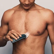 Image of a man using the groomer to shave his chest
