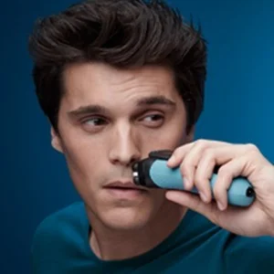 Man using a Braun trimmer on his nose, demonstrating precise hair removal.