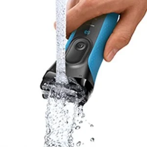 Braun shaver being rinsed under running water, demonstrating its waterproof design.