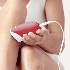 Braun hair removal device being used on a woman's leg.
