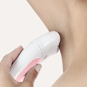 Braun epilator being used on a woman's underarm, demonstrating hair removal.