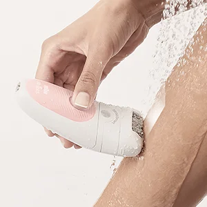 Braun Silk-épil being used on a leg under running water, highlighting its wet and dry functionality.