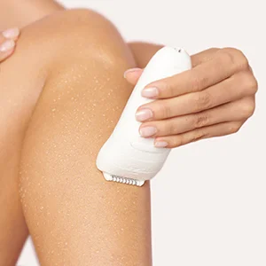 Braun epilator being used on a woman's leg, showing smooth skin after hair removal.