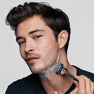 Man shaving his neck with a Braun razor, demonstrating a close and comfortable shave.