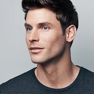 Man with short, styled hair and clean-shaven face, looking off to the side.