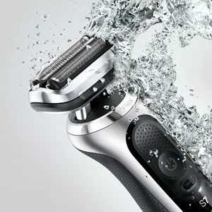 Braun Series 7 electric shaver being rinsed with water, highlighting its waterproof design.