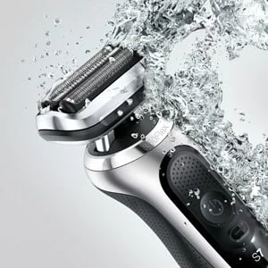 Braun Series 7 electric shaver shown with water splashing, highlighting its waterproof design.