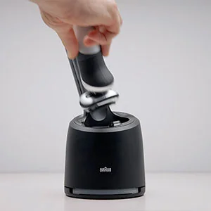 Braun shaver being placed into its charging and cleaning station.