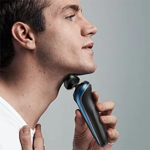 Braun electric shaver being used by a man to shave his neck.