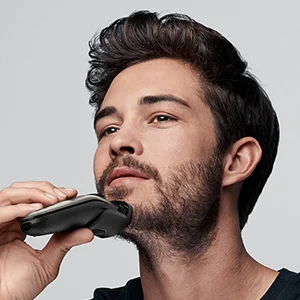 Braun shaver being used to trim a man's beard.