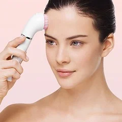 Braun cleansing brush being used on a woman's forehead, demonstrating its gentle facial exfoliation.