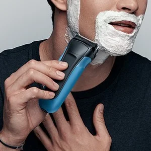 Braun electric shaver in use, demonstrating a close shave with shaving cream.