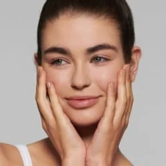 Braun product user with hands on face, smiling.