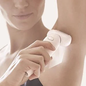 Braun epilator being used on a woman's underarm, demonstrating smooth hair removal.