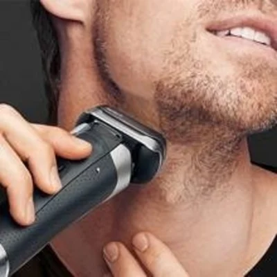 Braun electric shaver being used on a man's face, demonstrating a close shave.