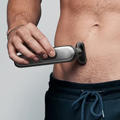 Braun trimmer being used on a man's torso, demonstrating body grooming.