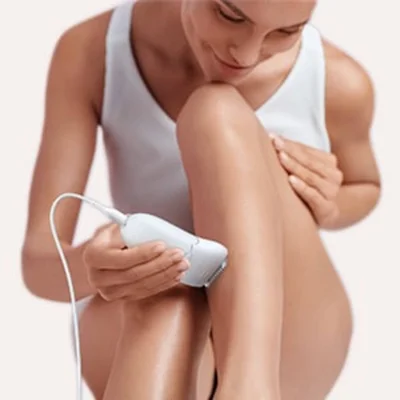 Braun epilator being used on a woman's leg, demonstrating hair removal.