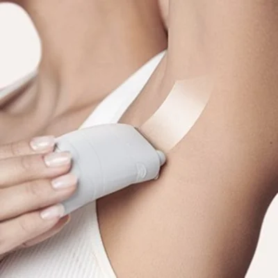 Braun Silk-épil epilator being used on an underarm, showing smooth skin after hair removal.