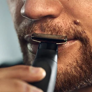 Image of a man using the trimmer on his moustache