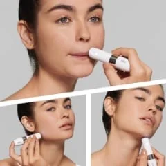 Braun facial epilator being used on the upper lip, cheek, and chin for precise hair removal.