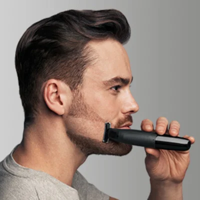 Man using a Braun trimmer to edge his beard.