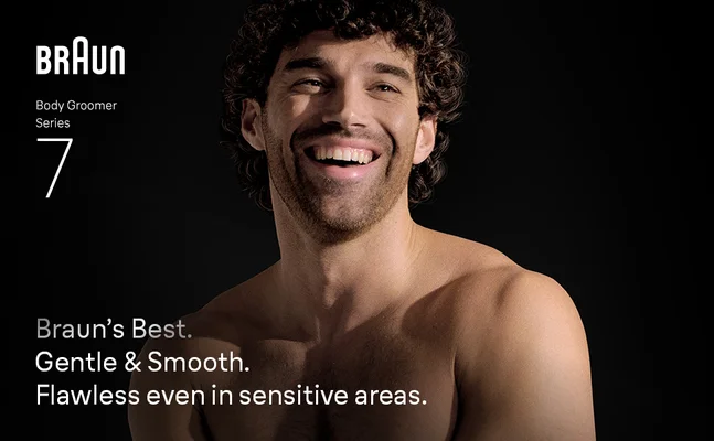 Young shirtless man smiling confidently after using the Braun Body Groomer Series 7.