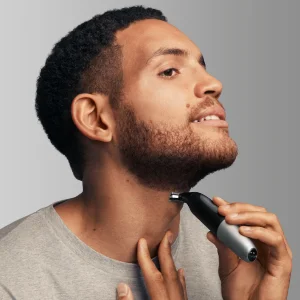 Man trimming his beard with a Braun trimmer, demonstrating its use for detailed grooming.