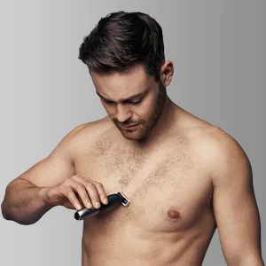 Braun trimmer being used on a man's chest to trim body hair.