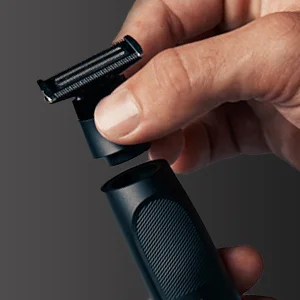 Braun trimmer head being removed from the handle for cleaning or attachment replacement.