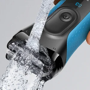 Braun Series 3 electric shaver being rinsed under running water, highlighting its waterproof design.
