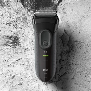 Braun Series 3 electric shaver against a textured, cracked background, showcasing its sleek design.